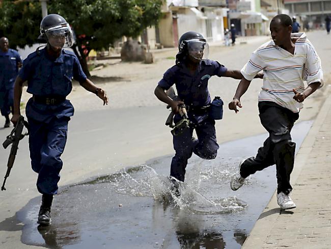 Polizisten verfolgen einen Demonstranten in Bujumbura, Burundi